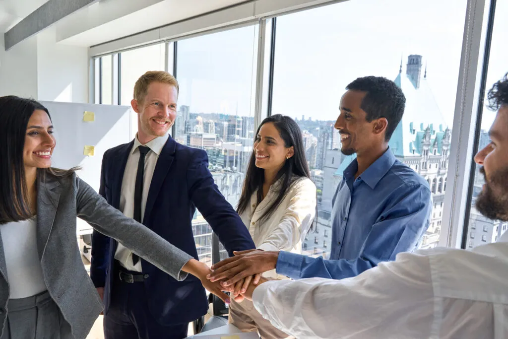 Business professionals joining hands in a collaborative team meeting