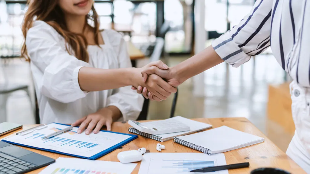 Business partners shaking hands over plans