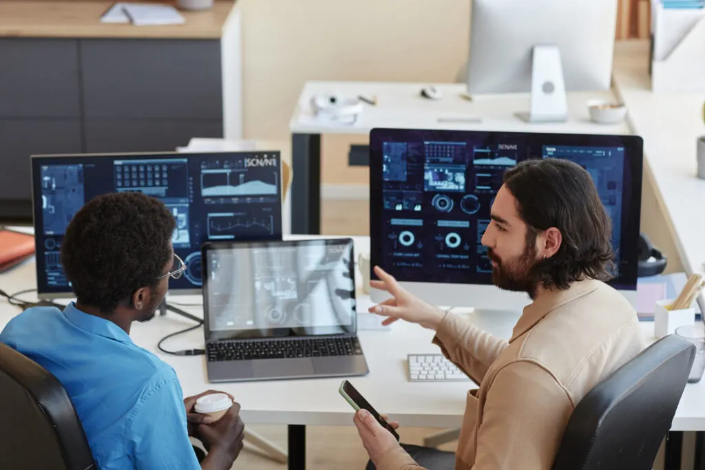 IT engineers reviewing technical dashboards