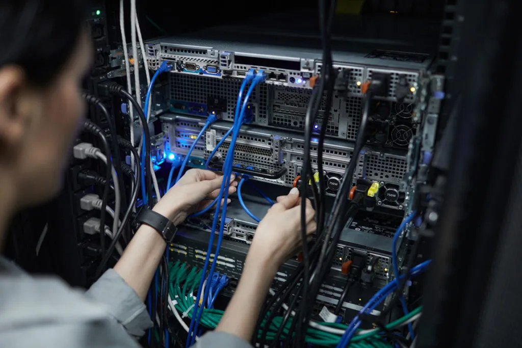 Network technician connecting cables in a data center